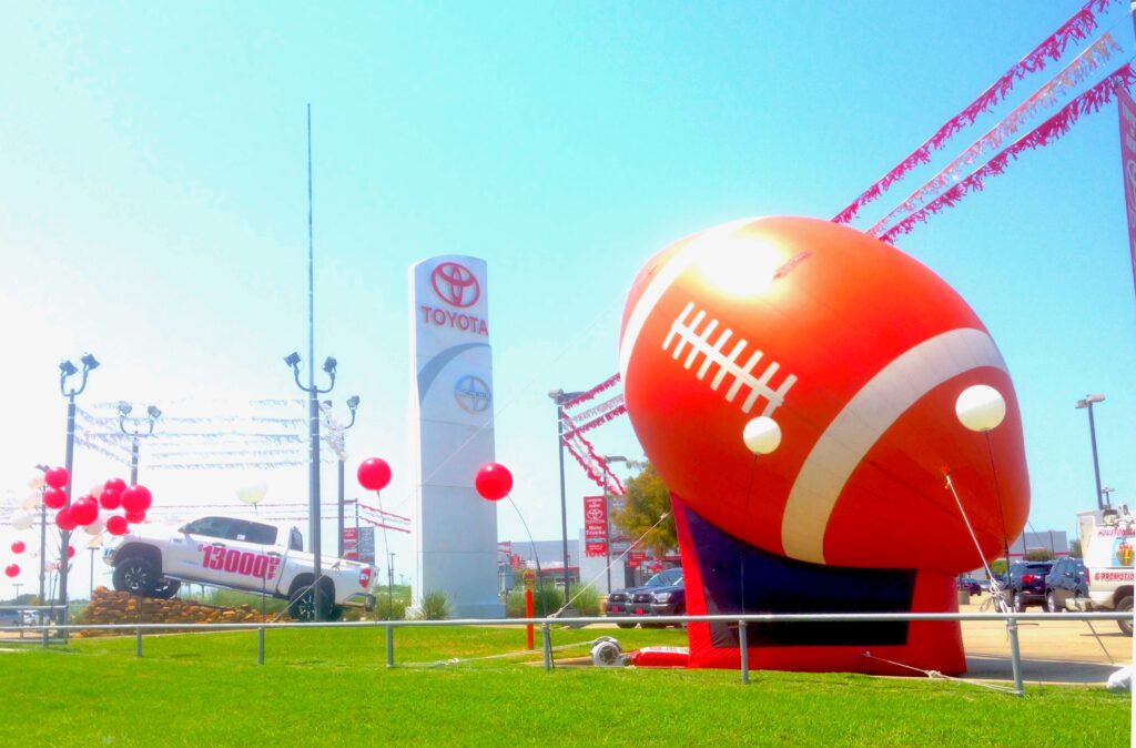 automotive dealership using giant football to promote sale
